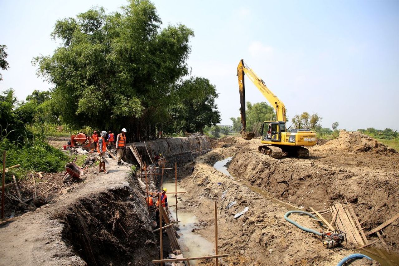 Pembuatan saluran air/ tanggul di Pakal untuk mengatasi luapan air kiriman dari Gresik. (Ist)