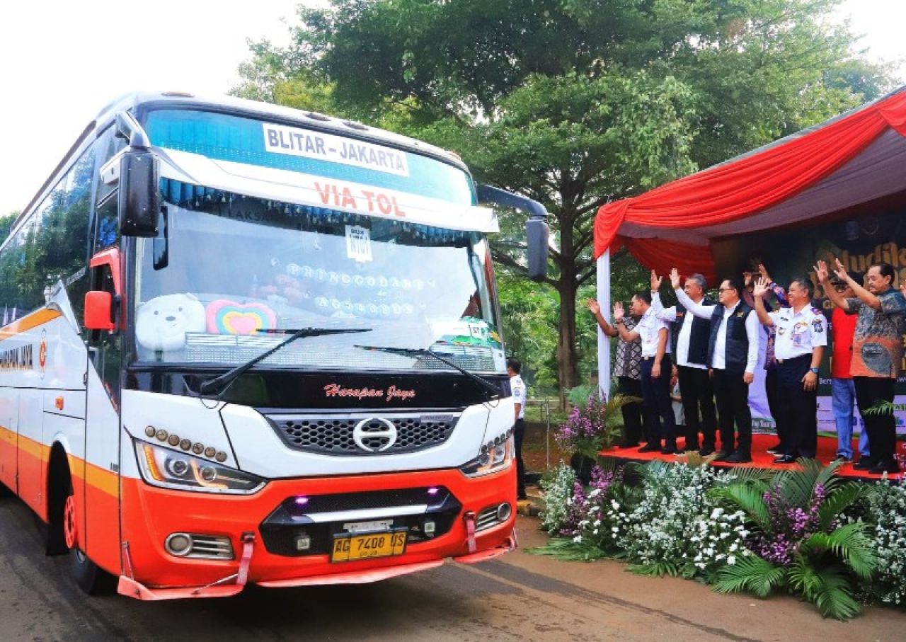 Pj Gubernur Adhy melambaikan tangan usai memberangkatkan pemudik gratis rute Jakarta - Jatim. (Ist)