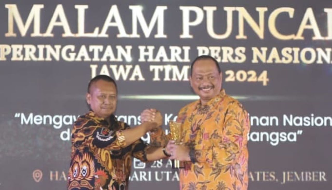 Ketua KONI Jatim saat menerima penghargaan dari Ketua PWI Jatim. (Ist)
