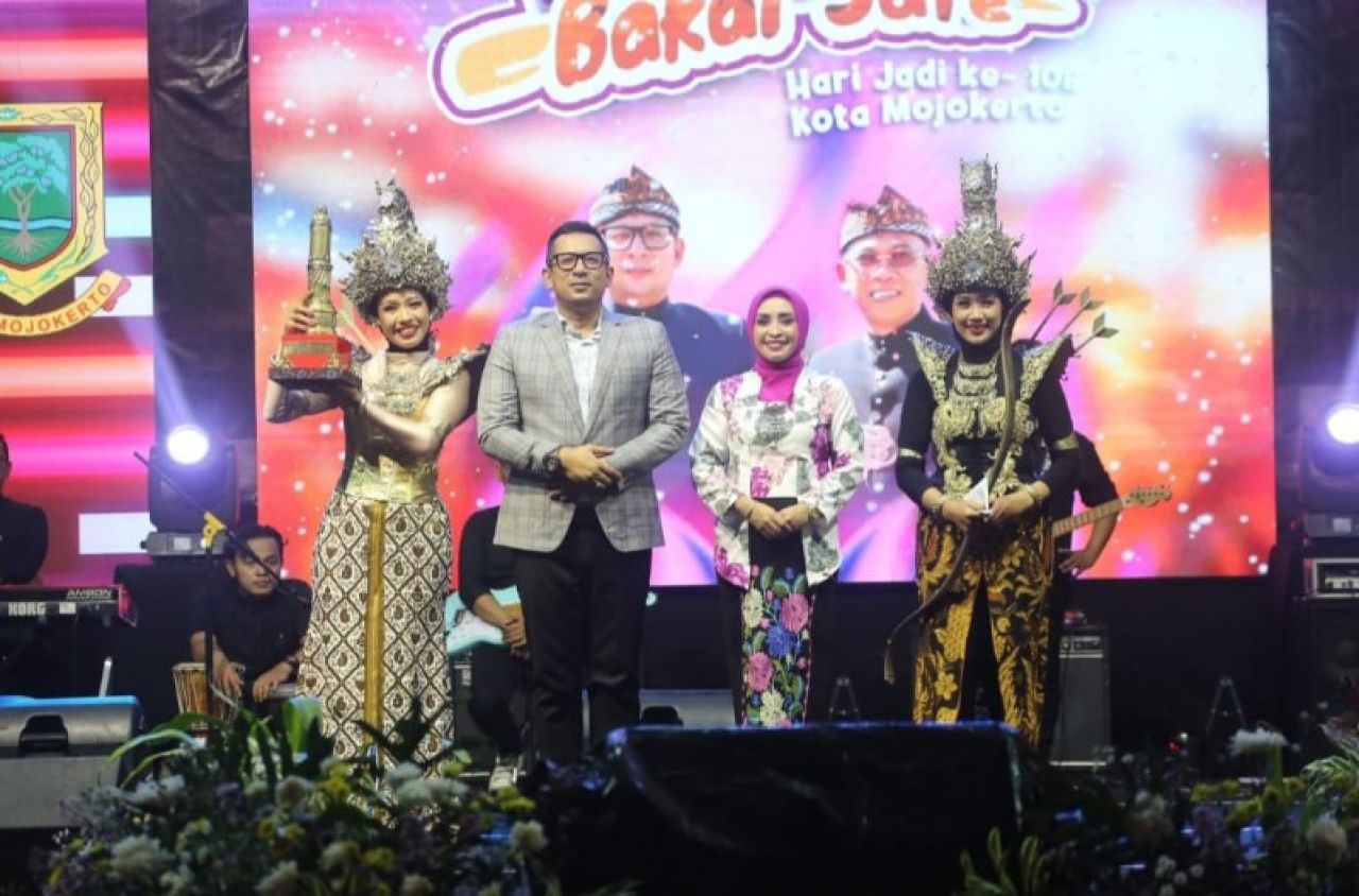 Mas Pj didampingi Ketua TP PKK Kota Mojokerto Nia Wayanti Ali Kuncoro menyerahkan trophi juara umum. (ist)