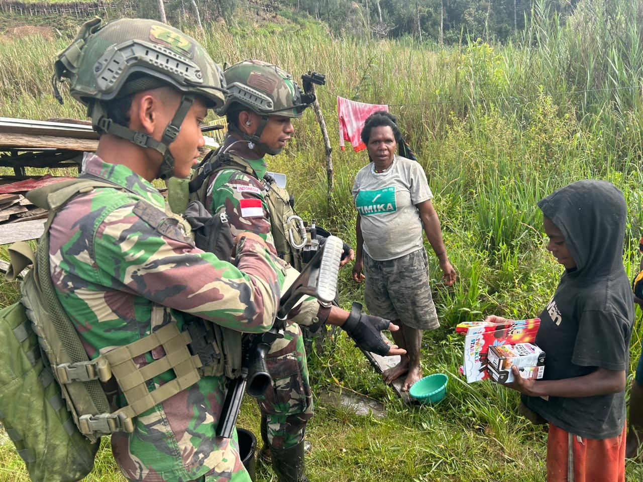Petugas Jaga TNI Membantu berikan makanan warga Dekai Yokuhimo Papua. (Ist)