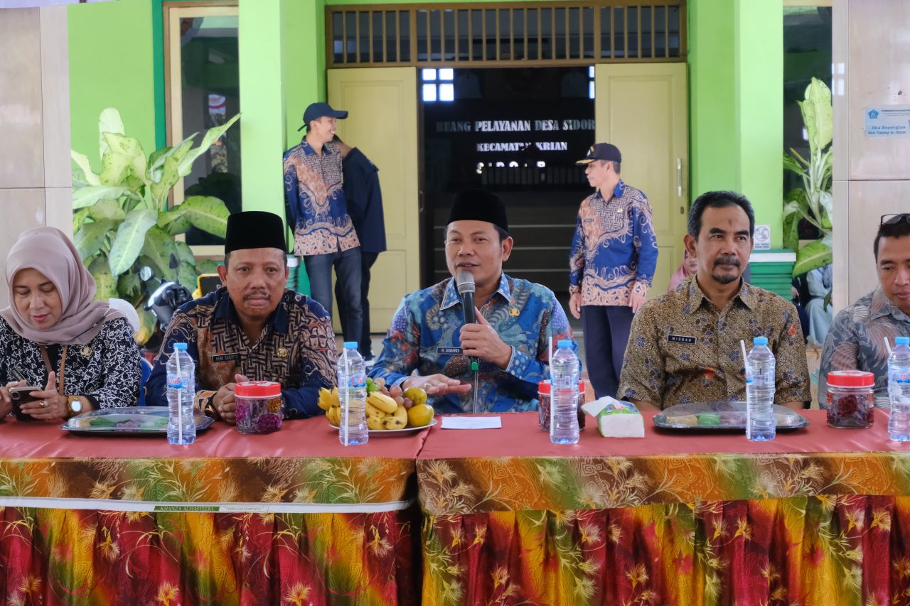 Plt Bupati Sidoarjo Subandi didampingi Kadinsod Saat penyaluran beras di Kecamatan Krian. (Ist)