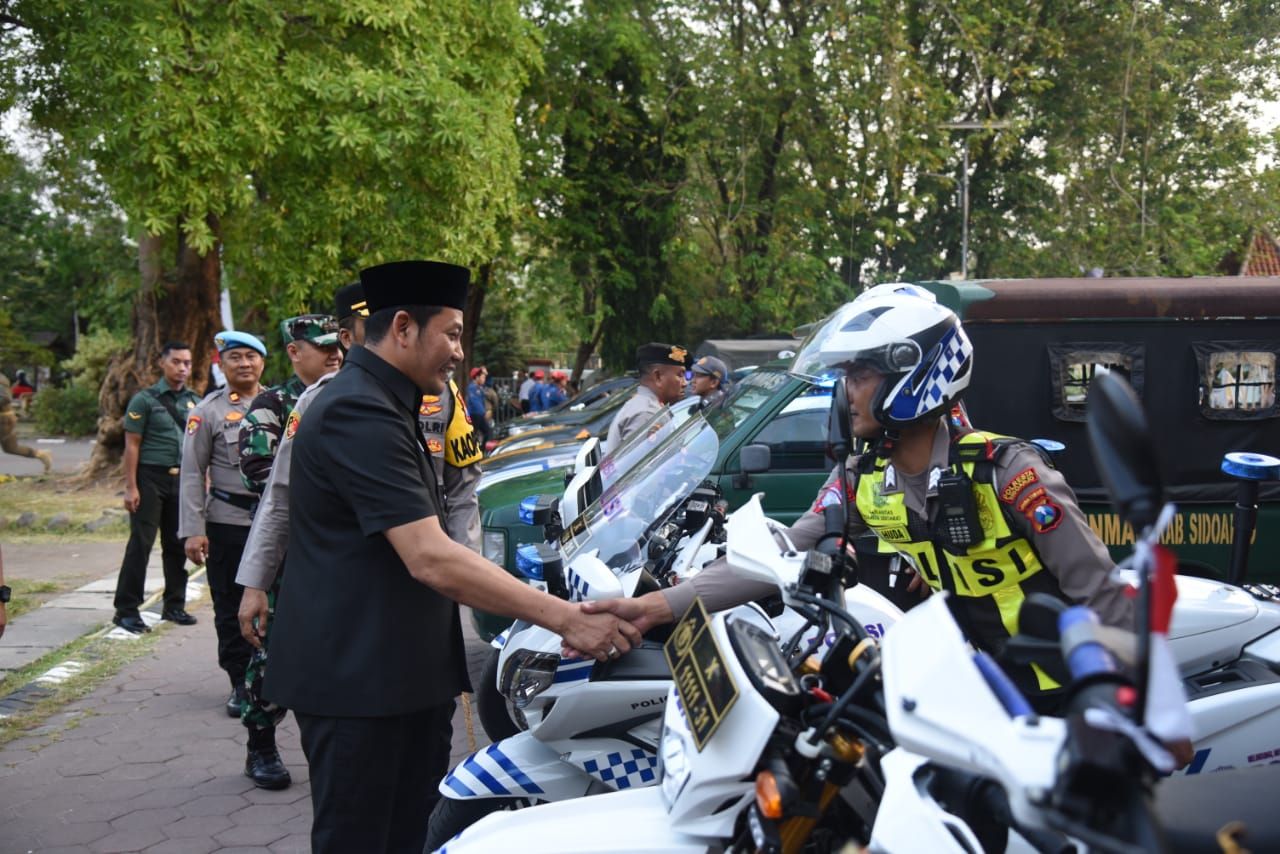 Plt Bupati Subandi menyalami petugas usai apel pengamanan Pilkada. (Ist)