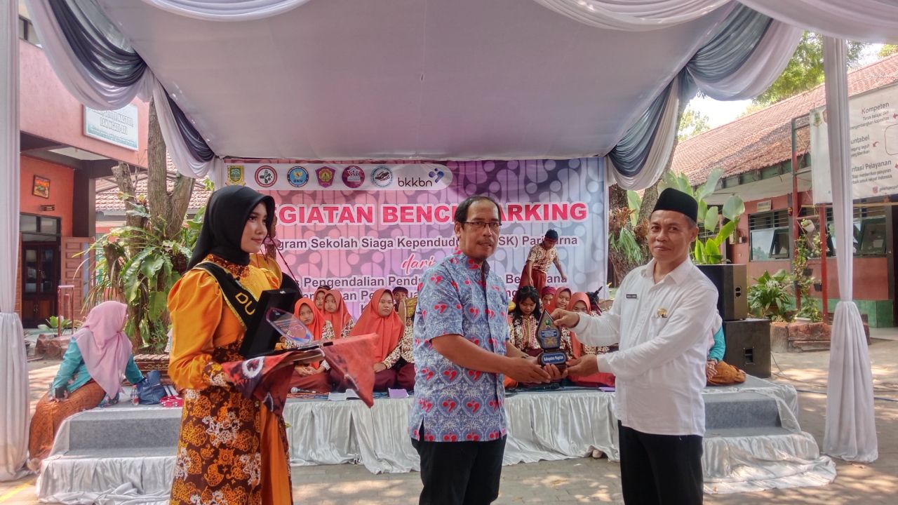 Kepala sekolah SMPN 4 Kota Mojokerto Mochamad Yasin menerima cindera mata dari Dinas Pengendalian Penduduk, Keluarga Berencana, Pemberdayaan Perempuan dan Perlindungan Anak Kabupaten Magetan. (ist)