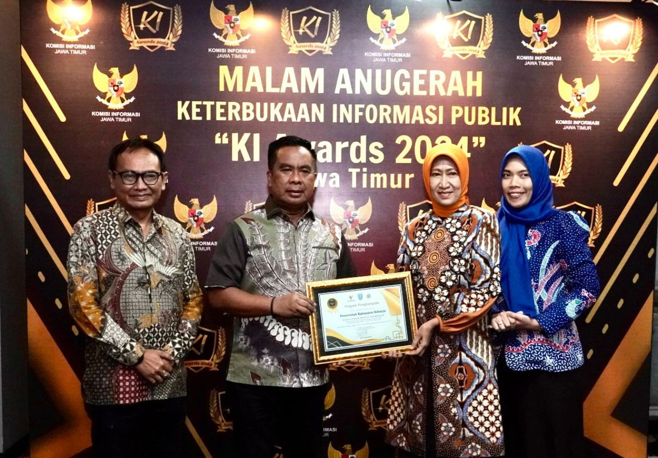 Pj Bupati Sidoarjo M Isa Anshori memamerkan penghargaan KI Award 2024 yang diperoleh Pemkab Sidoarjo. (Ist)