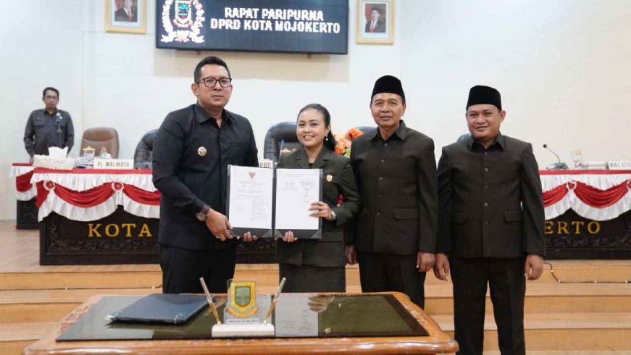 Pj Wali Kota Mojokerto Moh Ali Kuncoro bersama jajaran pimpinan DPRD memperlihatkan penghargaan yang diterima. (ist)