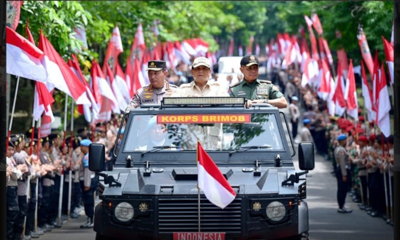Presiden Prabowo Subianto menaiki kendaraan taktis maung disambut lambaian bendera para pelajar dan masyarakat. (ist)
