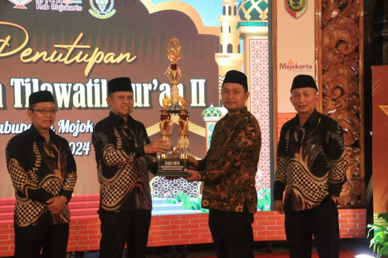 Sekretaris Daerah Kabupaten Mojokerto Teguh Gunarko menyerahkan piala juara umum MTQ II kepada Kecamatan Mojoanyar. (ist)