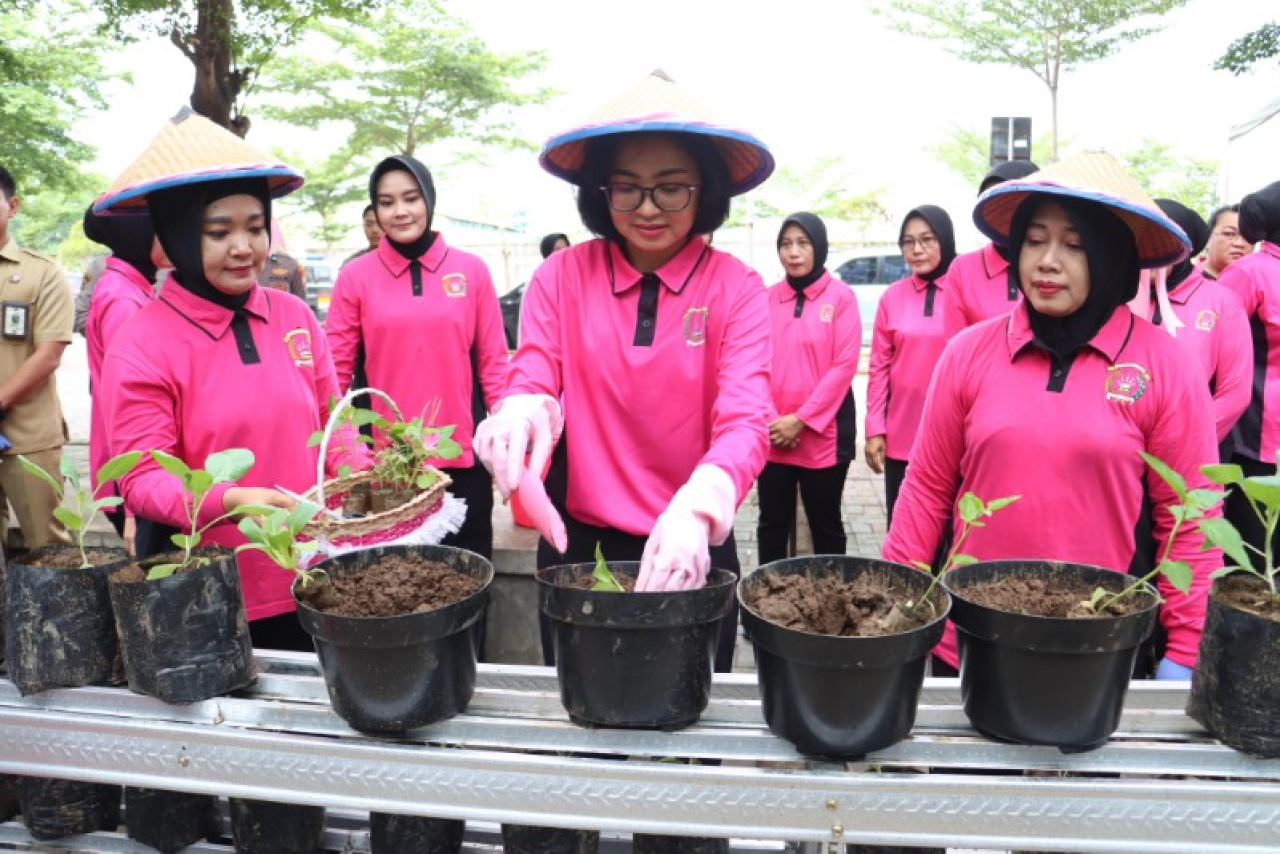 Ketua Bhayangkari Ny Andani Daiel dan Ibu-ibu Bhayangkari Kota Mojokerto menanam aneka tanaman pangan di satpas Kota Mojokerto. (ist)