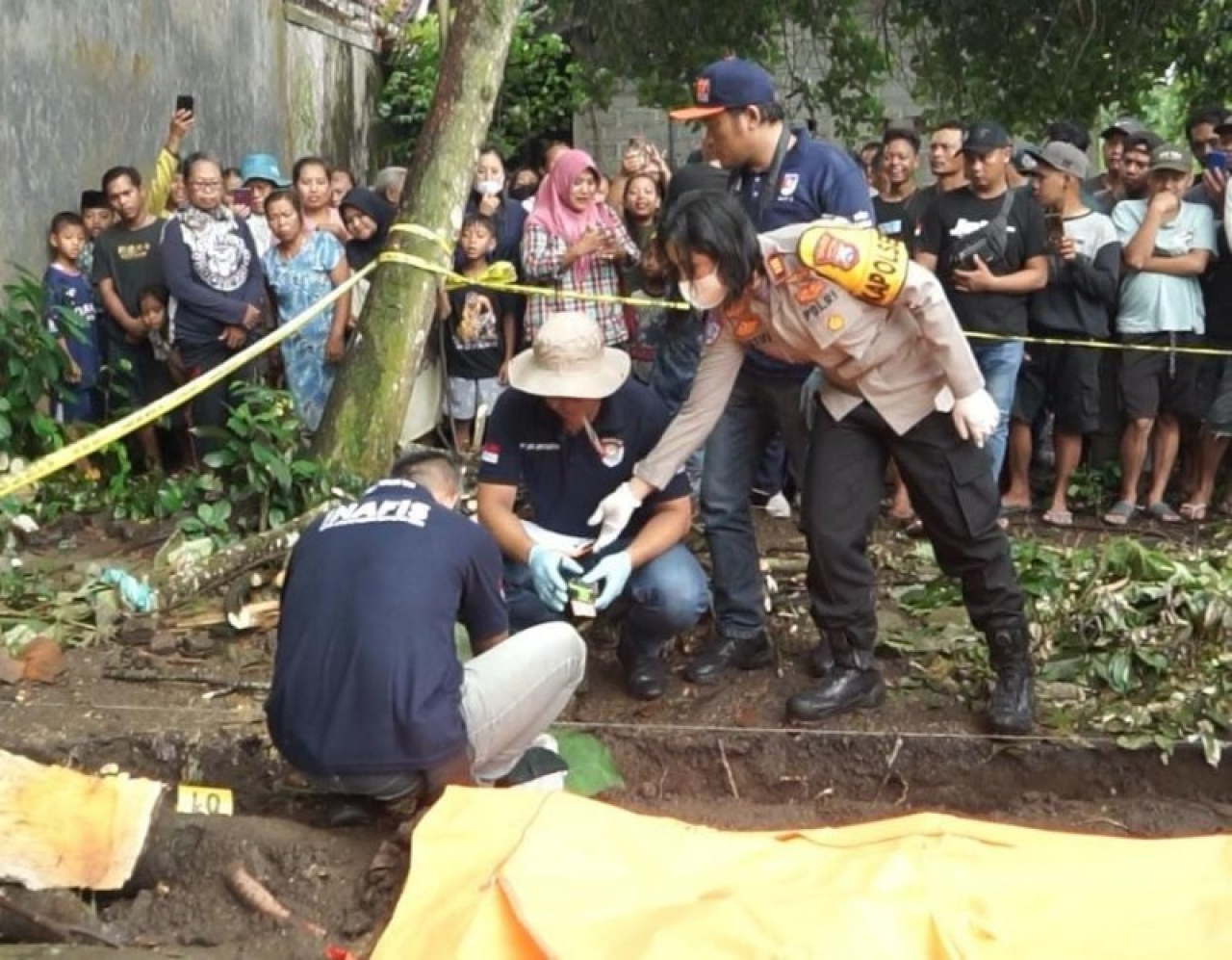Unit Reskrim Polsek Ambulu bersama Tim Kalong Polres Jember mengevakuasi jasad bayi laki-laki di pekarangan. (ist)