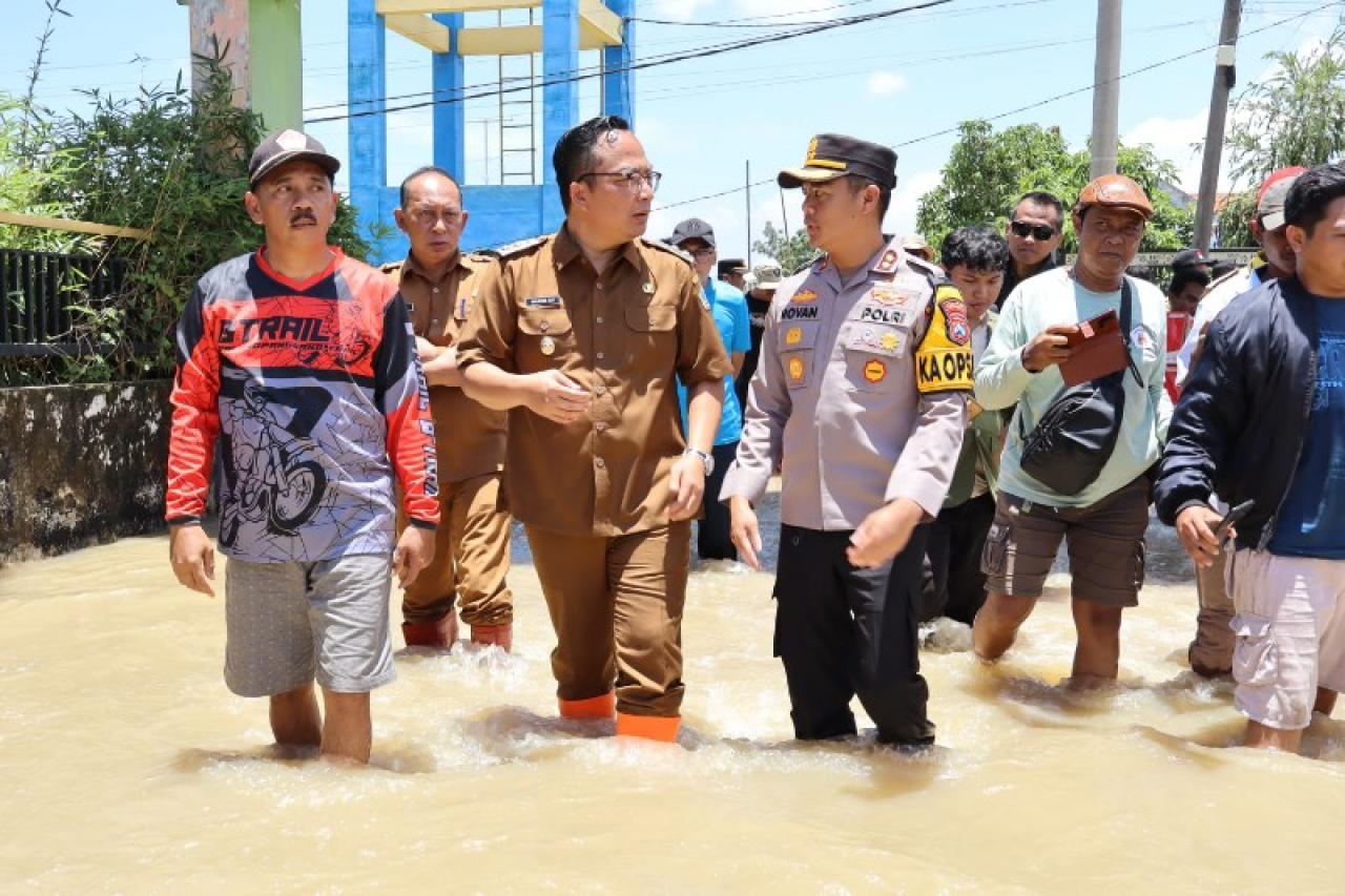 Wakil Bupati dan Kapolres Gresik menerjang genangan untuk menjenguk warga kebanjiran. (ist)