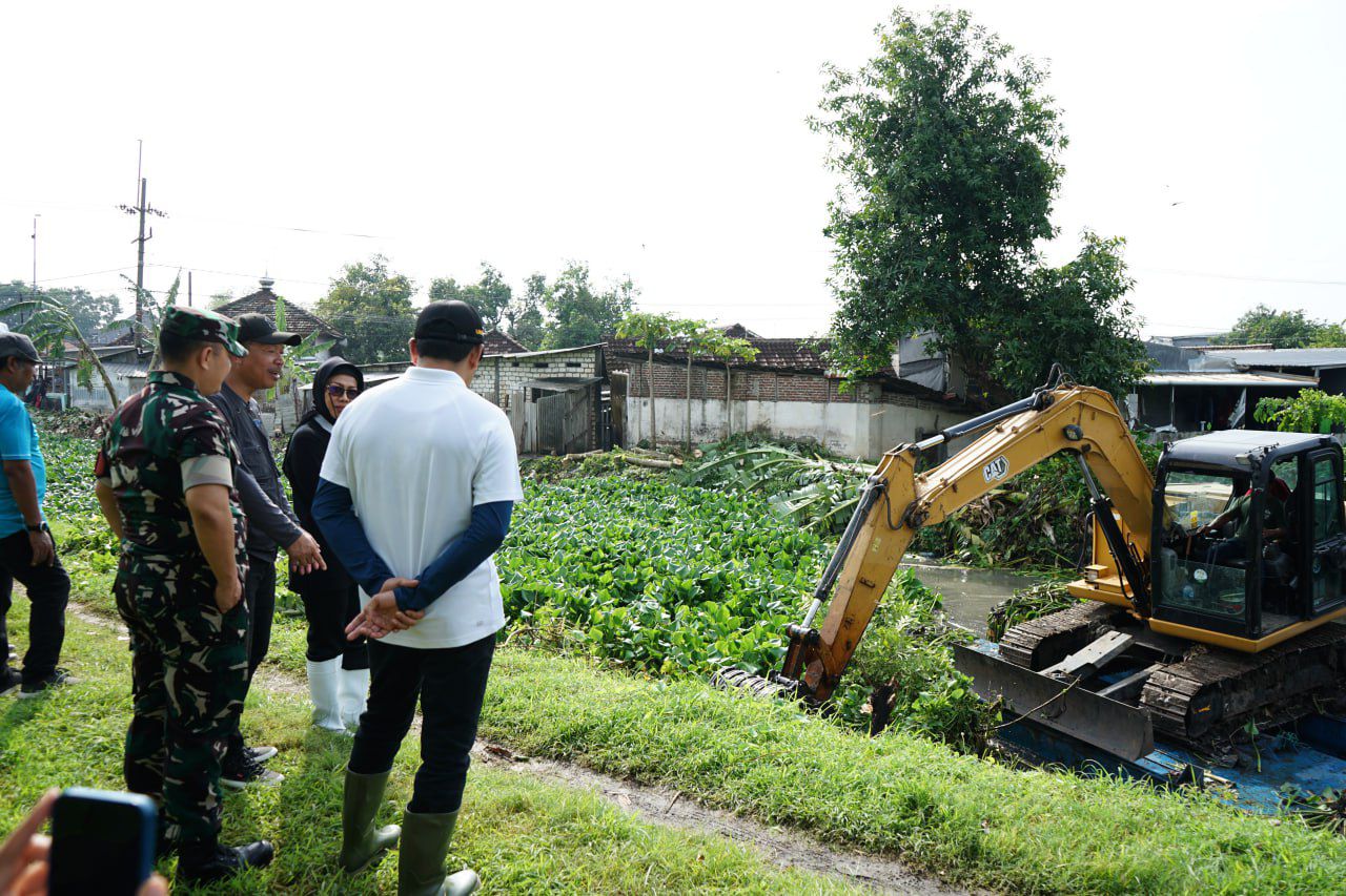 Plt Bupati Sidoarjo, Subandi ( kaos putih) membelakangi kamare saat meninjau pembesiihan eceng gondok di sungai Klurak Kecamatan Candi. (*)