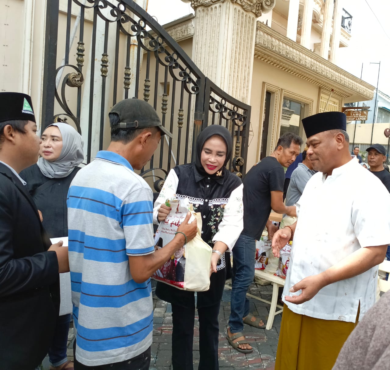H Rahmat Muhajirin beserta Hj Mimik Idayana saat membagikan paket sembako di kediamannya Kompleks Perumahan TNI AL Desa, Sugihwaras Kecamatan Candi Sidoarjo. (foto : zainul/ B-news.id)