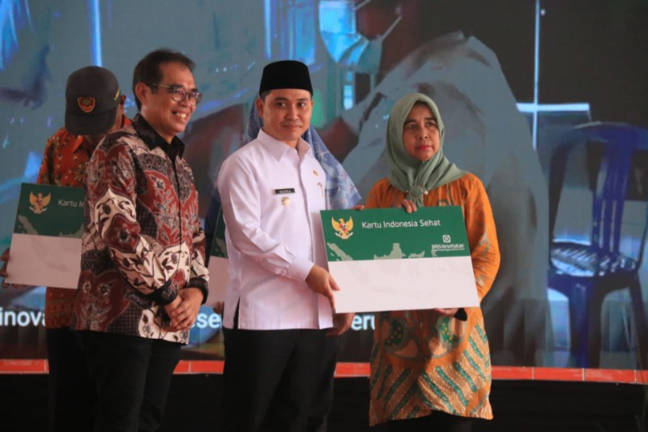 Bupati Mojokerto Muhammad Al Barramenyerahkan kartu BPJS secara simbolis pada Lounching UHC Prioritas. (ist)