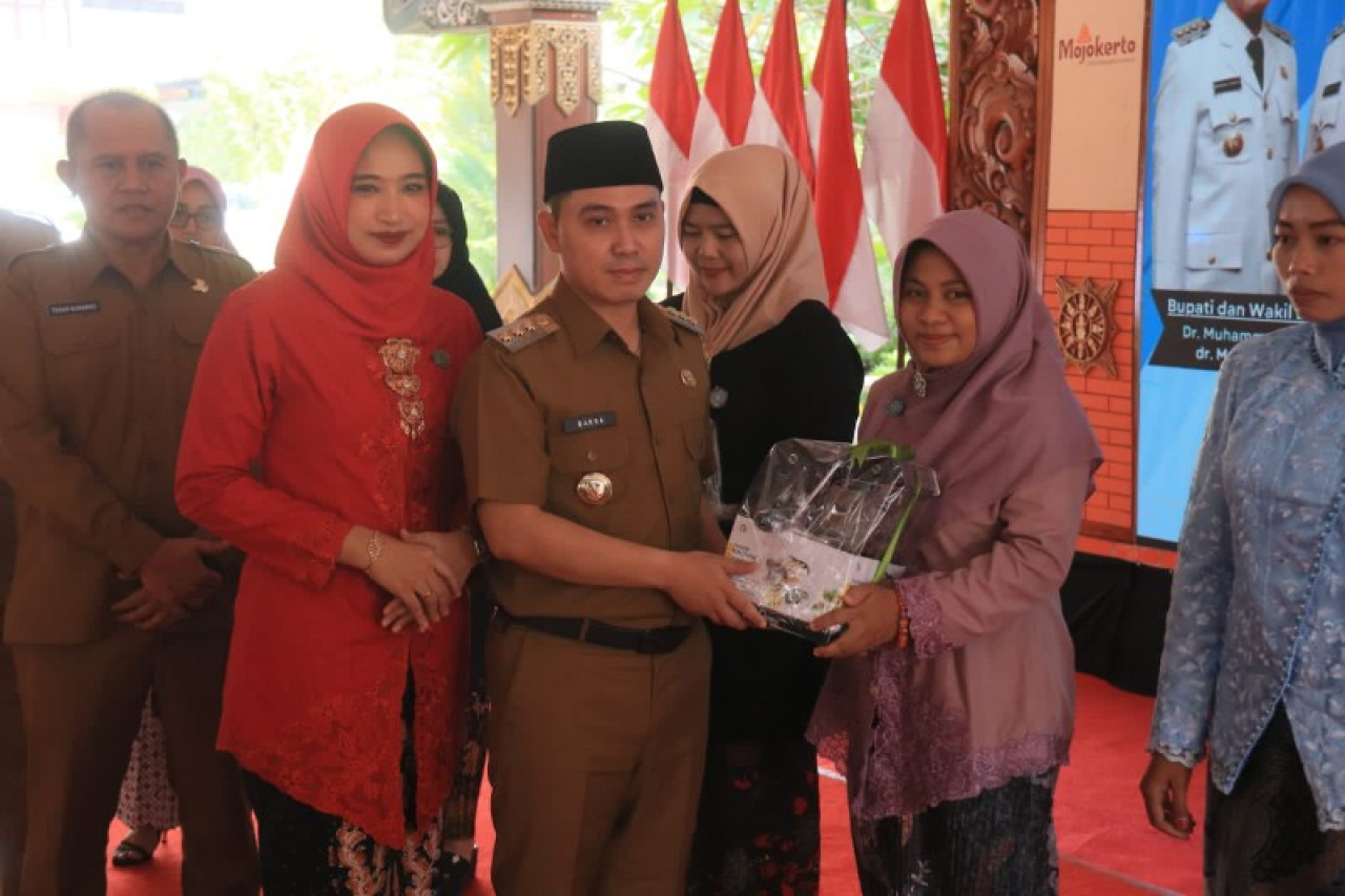 Bupati Mojokerto Gus Barra didampingi Ketua TP PKK Kabupaten Mojokerto Shofiya Hana menyampaikan bingkisan kepada ibu-ibu UMKM. (ist)