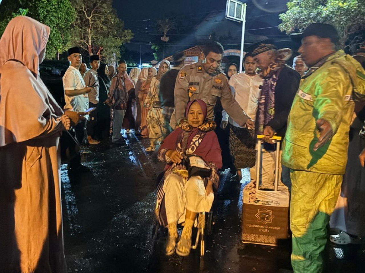 Anggota Polres Mojokerto Kota cepat tanggap bantu jemaah haji dengan kursi roda. (ist)