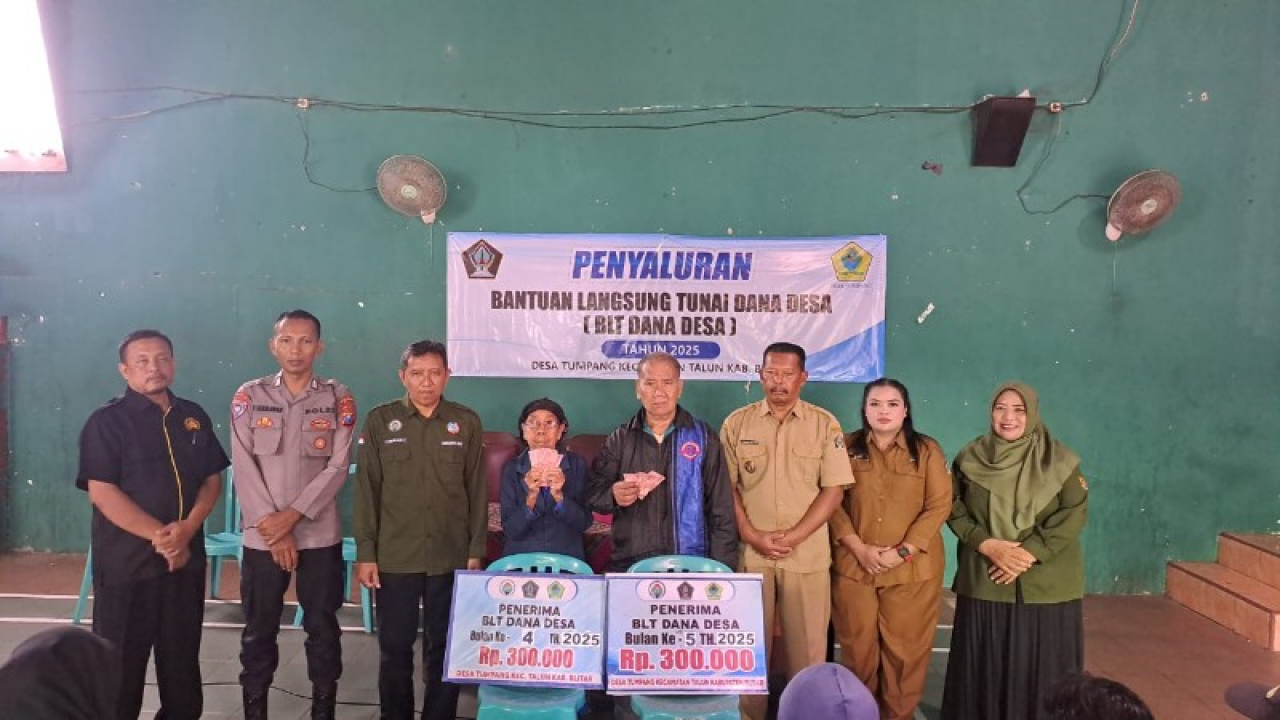 Kepala Desa Tumpang Agus Salim bersama warga penerima manfaat foto bersama usai penyaluran BLT DD. (ist)