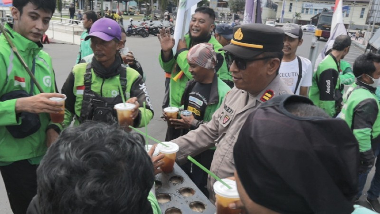 Anggota Polres Jember tuai simpati, bagikan minuman dingin ditengah bertugas pengamanan aksi unras. (ist)