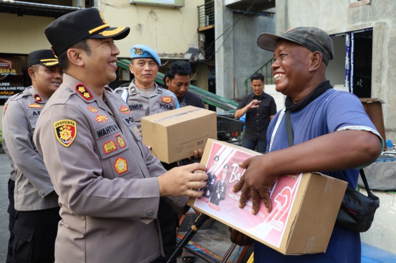 Kapolres Tanjungperak AKBP Wahyu Hidayat didampingi Wakapolres berbagi paket sembako kepada pengemudi Bentor dan Kuli Pelabuhan. (ist)