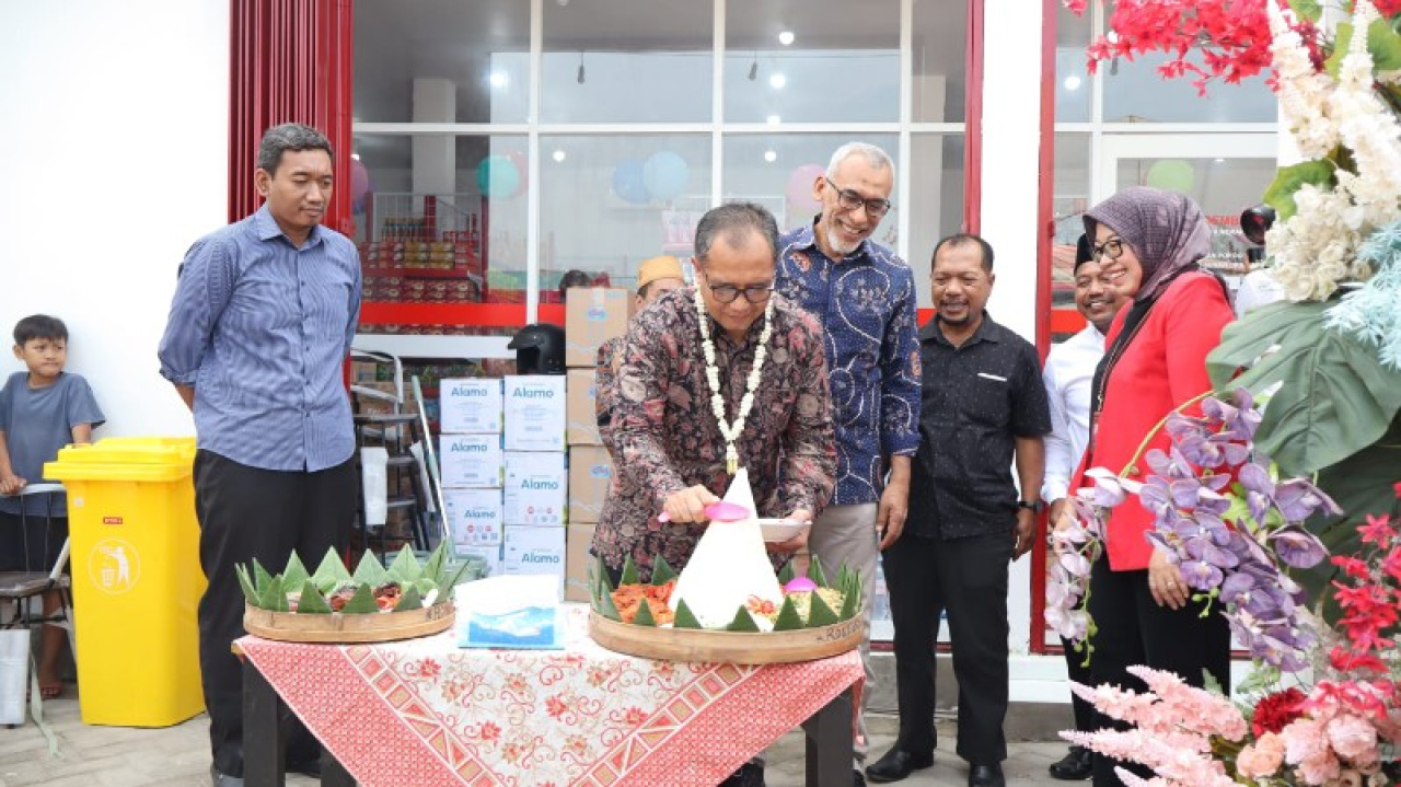 Sekda Gresik memotong tumpeng disaksikan Kepala Diskoperindag. (ist)