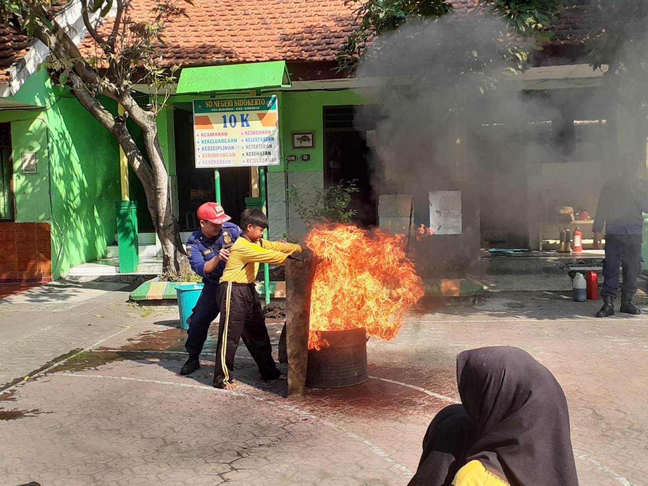 Salah seorang siswa SDN Sidokerto yang mencoba memeragakan padamkan api dengan karung goni basah.(ist)