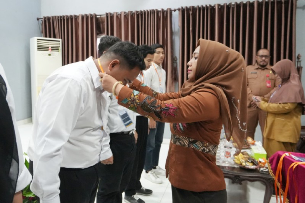 Ning Ita mengalungkan tanda peserta, menandai dimulainya pelatihan. (ist)