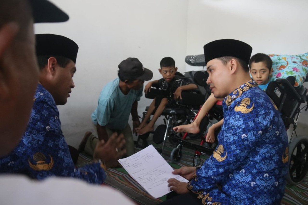 Bupati Mojokerto Muhammad Al Barra saat menyerahkan bantuan kursi roda kepada 2 anak disabilitas di Modopuro Mojosari. (ist)