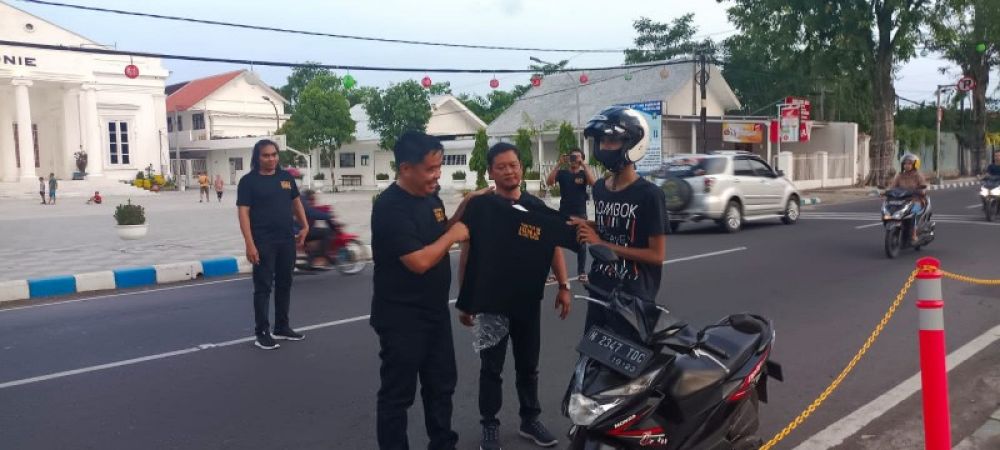 Petugas Polres Kota Petugas Polres Kota Pasuruan saat membagikan kaos HANI kepada pengendara yang lewat. (Ist) 