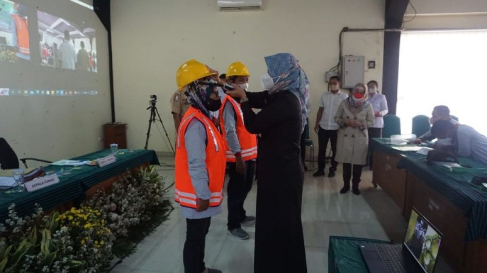 Bupati Bojonegoro Anna Mu'awanah memasangkan salah satu atribut pelindung kepala kepada peserta uji sertifikasi kompetensi konstruksi jalan. (Ist) 