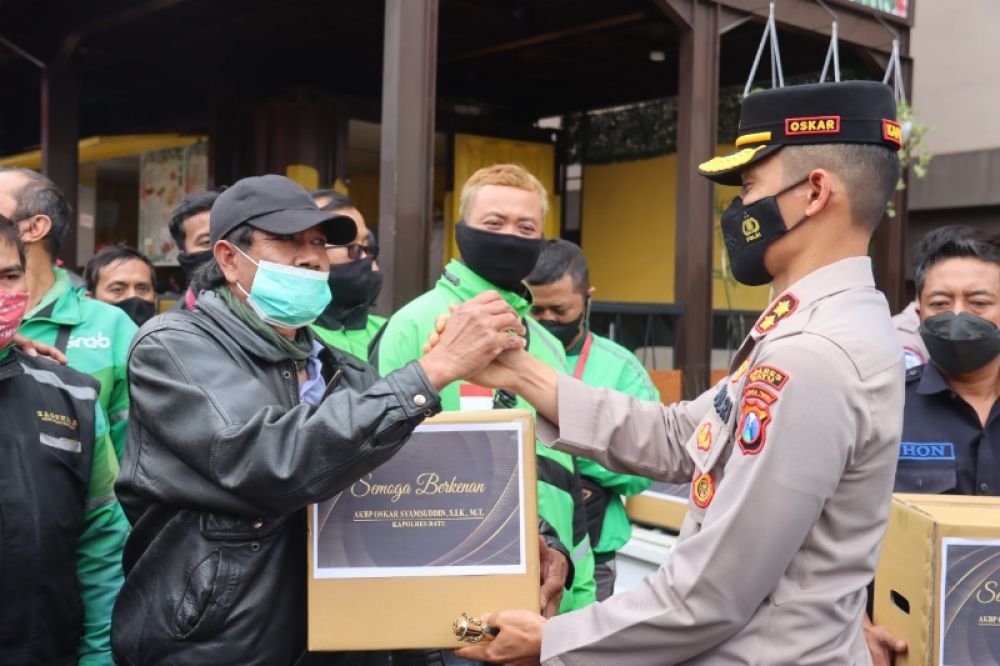 Kapolres Batu AKBP Oskar Syamsuddin saat membagikan paket sembako kepada puluhan ojol. (ist) 