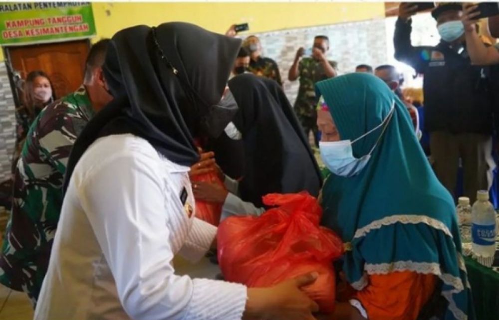 Bupati Mojokerto Ikfina menyerahkan bantuan sosial kepada warga kurang mampu. Foto Bawah: Para pejabat pembuat akte tanah (PPAT) dalam ajang notaris masuk desa sedang berfoto dengan Bupati Ikfina. (Ist) 