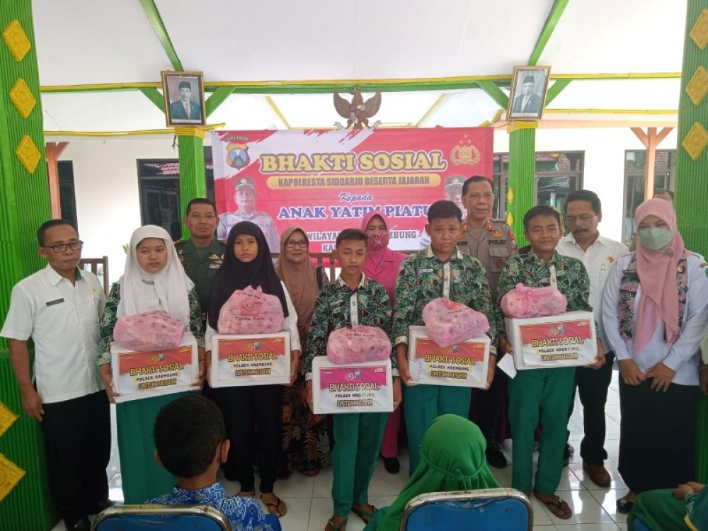 Kapolsek Krembung AKP Imam Yuwono, Forkopimka beserta Bhabinkamtibmas dan Babinsa Desa Mojoruntut usai serahkan bantuan. (Ist) 