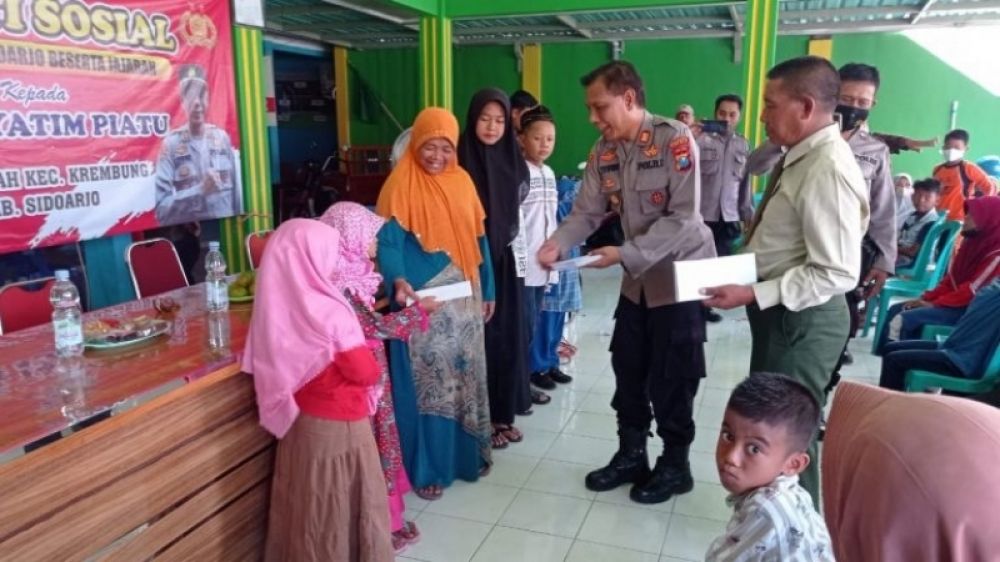Kapolsek Krembung AKP Imam Yuwono saat menyerahkan santunan yatim piatu dan minta didoakan agar .diberikan kemudahan bertugas dan selalu kompak. (Ist) 