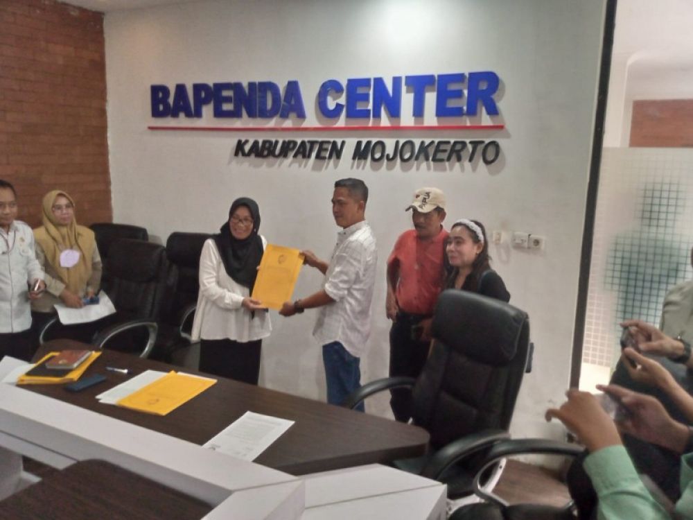 Penyerahan dokumen hasil audiensi LSM Baracuda dengan Bapenda Kabupaten Mojokerto oleh Kepala Bapenda Kabupaten Mojokerto Mardiasih kepada Ketua Umum Pusat Baracuda Indonesia Hadi Purwanto. (foto: ram)