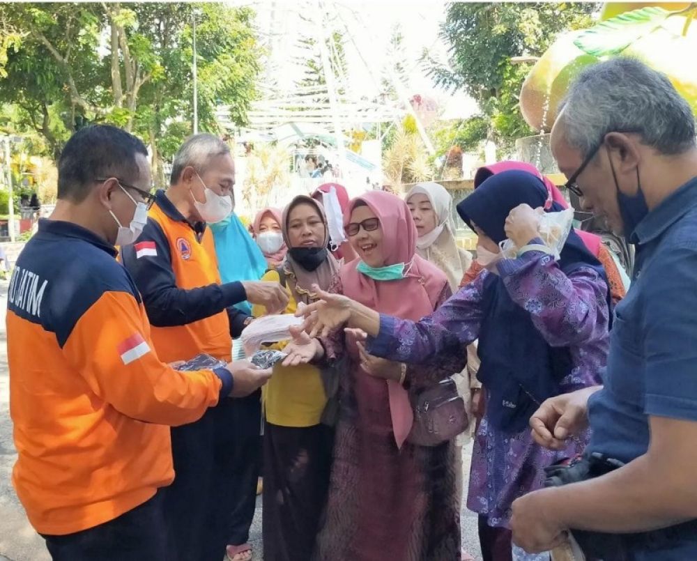 Kalaksa BPBD Jatim, Budi Santoso membagikan masker kepada pengunjung wisata kota Batu dan KBS Surabaya (Ist) 