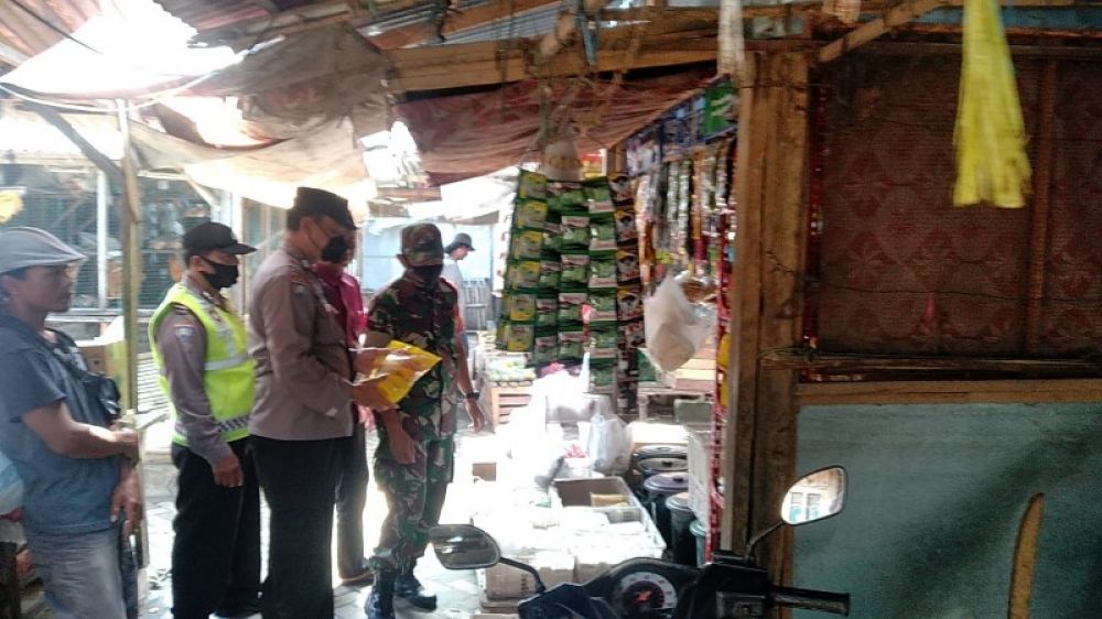 Anggota Polsek Plosoklaten saat memantau distribusi minyak goreng dan memastikan ketersediaan aman. (Ist) 