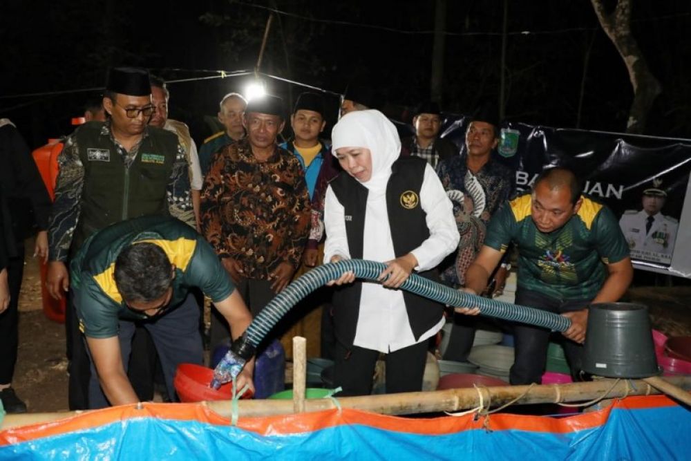 Gubernur Khofifah didampingi Kalaksa BPBD Jatim membantu mengisi jirigen air warga untuk didistribusikan. (Ist) 