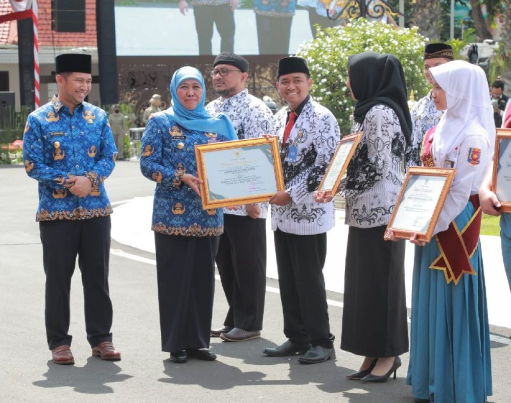 Gubernur Khofifah didampingi Wagub Emil Dardak saat berikan penghargaan kepada guru. (Ist) 