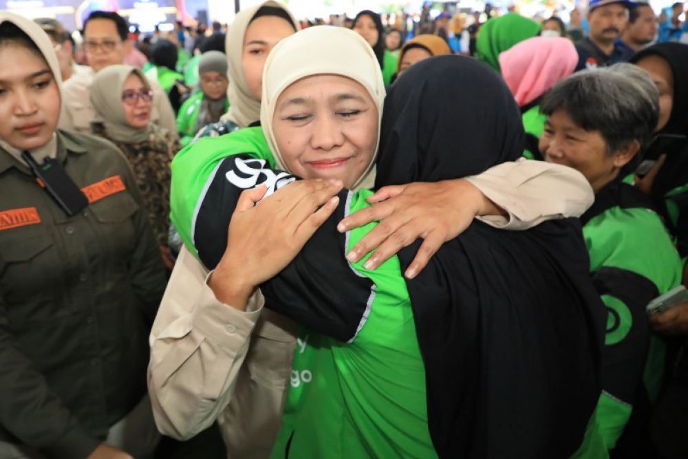 Gubernur Khofifah memeluk seorang ibu muda driver aplikasi online. (Ist(