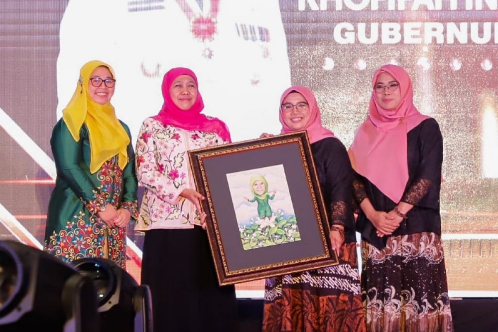 Gubernur Khofifah menerima cindera mata gambar lukisan. (Ist) 