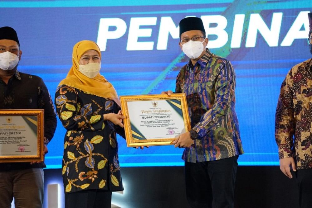 Gubernur Jawa Timur, Khofifah Indar Parawansa menyerahkan penghargaan kepada Bupati Sidoarjo, Muhdlor Ali di acara Puncak Peringatan Hari Koperasi ke 75 Jatim Tahun 2022 di Grand City Surabaya. (Ist) 