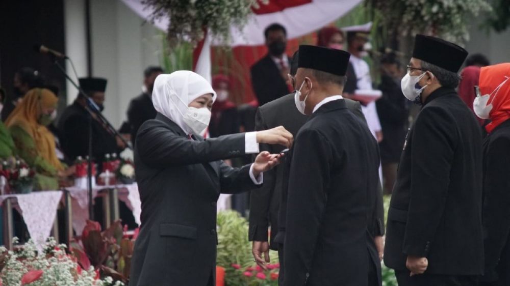Gubernur Khofifah menyematkan Lencana kepada guru yang sudah mengadi diatas sepuluh tahun usai upacara Hardiknas 2022 di Grahadi Surabaya. (Ist) 