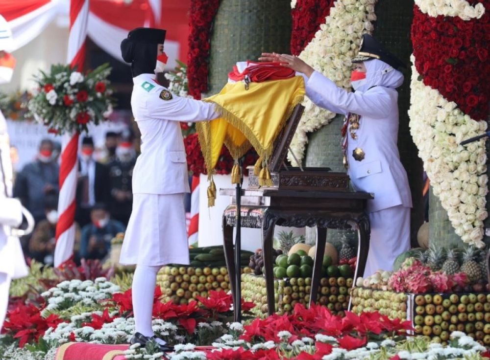 Gubernur Khofifah menyerahkan bendera merah putih kepada anggota paskibraka untuk disimpan dalam. Peti. (Ist) 