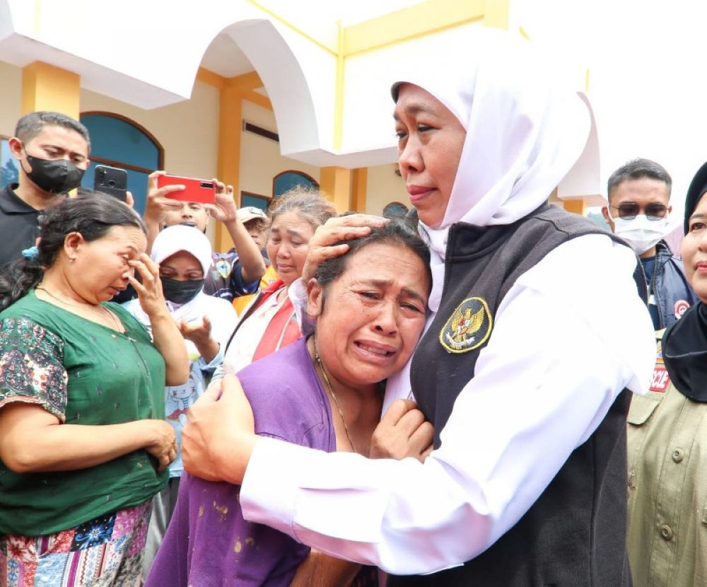 Seorang warga mengadj dan memeluk Gubernur Khofifah yang rumahnya hanyut terkena banjir bandang. (Ist) 