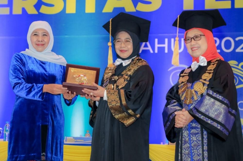 Gubernur Khofifah saat menghadiri Wisuda Universitas Terbuka Surabaya menerima kenang- kenangan dari Rektor. (Ist) 