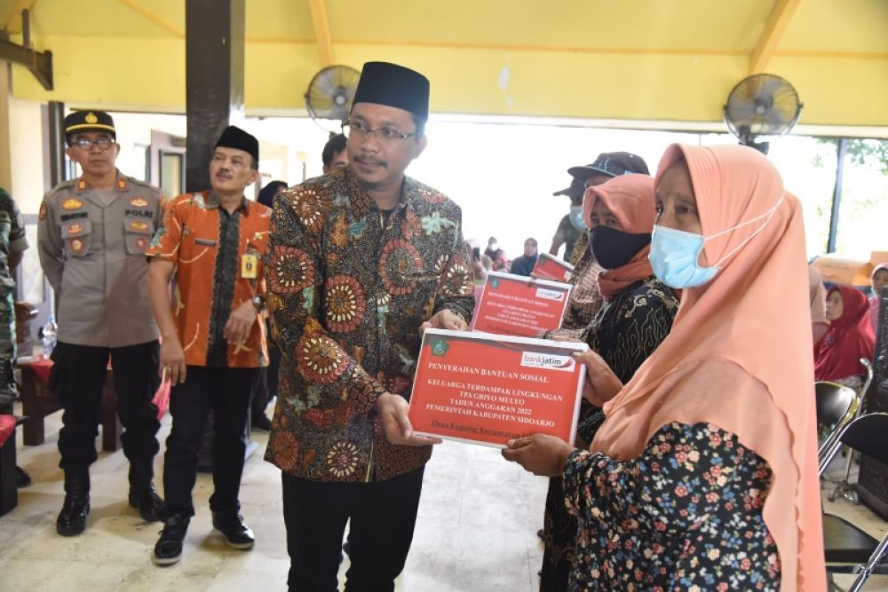 Bupati Gus Muhdlor menyerahkan bantuan sosial bagi ribuan warga yang tinggal di kawasan TPA Griyo Mulyo Jabon. (Ist) 