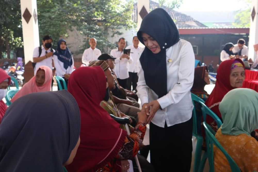 Bupati Ikfina menyalami dan menyapa warga penerima bantuan ATENSI klaster lansia di Pendopo Kecamatan Sooko. (ist)