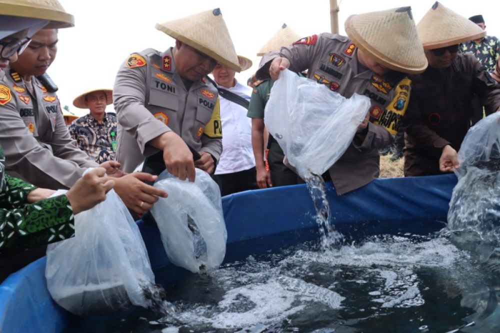 Kapolda Jatim didampingi Kapolres Blitar dan jajaran menebar bibit ikan. (ist) 