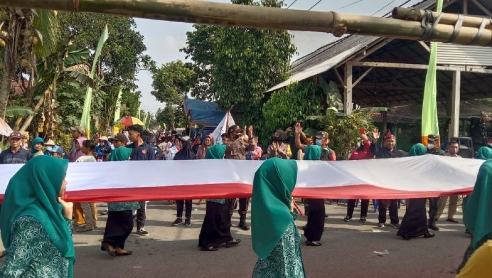 Warga Desa Dawung Kecamatan Ringinrejo Kediri mengarak bendera merah putih sepanjang 1 Km keliling Desa. ( ist) 