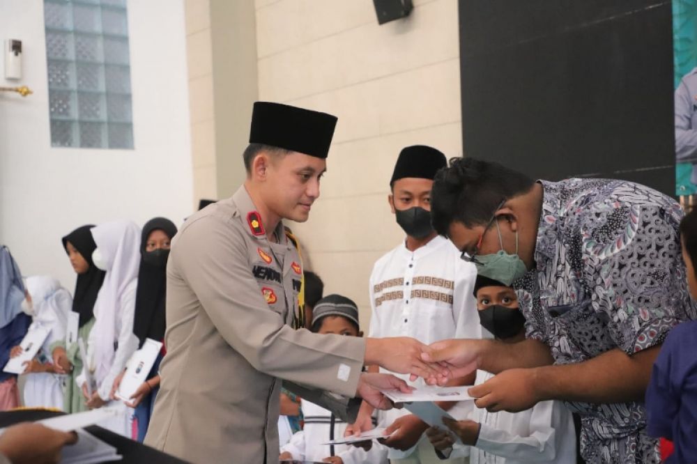 Kapolres Kediri AKBP Agung Setyo Nugroho menyerahkan santunan kepada Anak Yatim . (Ist) 